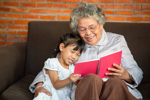 Grandmother reading to granddaughter